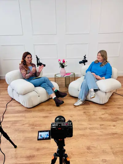 Host and guest in boucle chairs recording a video podcast