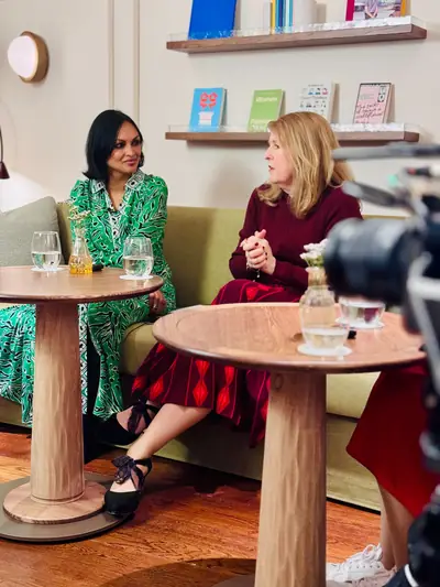 Guest in a green dress on a lounge set during a podcast recording